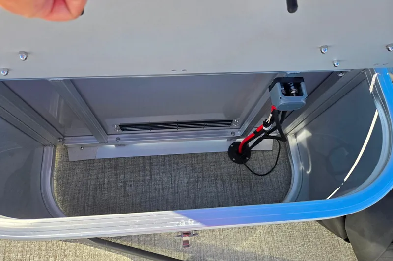 Slide: The Image of 2023 Avalon LSZ Quad Lounger storage compartment with wiring and carpeted interior. - 19