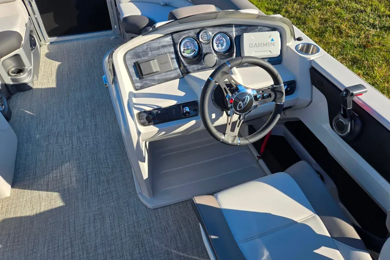 Slide: The Image of 2023 Avalon LSZ Quad Lounger boat interior with steering wheel and Garmin display. - 22