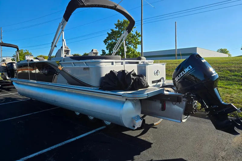 Slide: The Image of 2023 Avalon LSZ Quad Lounger pontoon boat with Suzuki outboard motor, parked outdoors. - 3