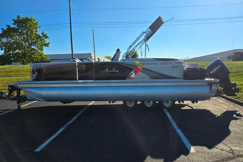 Slide: The Image of 2023 Avalon LSZ Quad Lounger pontoon boat with Suzuki outboard motor in parking lot. - 4
