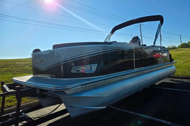 Slide: The Image of 2023 Avalon LSZ Quad Lounger pontoon boat on trailer under clear blue sky. - 5