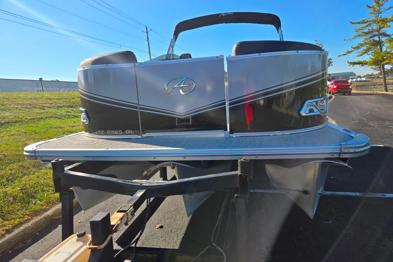 Slide: The Image of 2023 Avalon LSZ Quad Lounger pontoon boat on trailer, parked outdoors. - 6