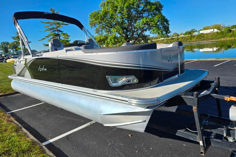 Slide: The Image of 2023 Avalon LSZ Quad Lounger pontoon boat parked near a serene lake. - 8