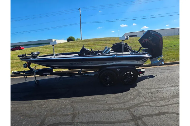 Slide: The Image of 2022 Phoenix 919 ProXP boat on trailer, parked outdoors under clear blue sky. - 4