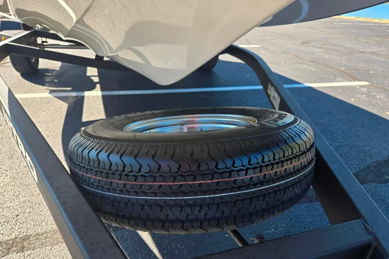 Slide: The Image of Trailer tire under Nitro Z18 Pro boat, 2022 model, parked on asphalt. - 8