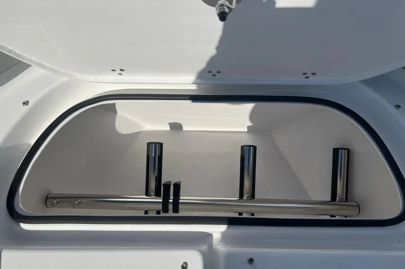 Slide: The Image of Open storage compartment on 2026 Cape Horn 27XS boat, featuring stainless steel rod holders. - 13