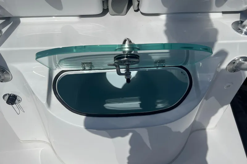 Slide: The Image of 2026 Cape Horn 27XS boat livewell with open glass lid, showcasing interior details. - 14