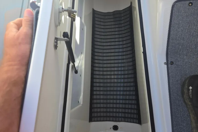 Slide: The Image of 2018 Yamaha Boats AR240 storage compartment with black mat and open hatch. - 13