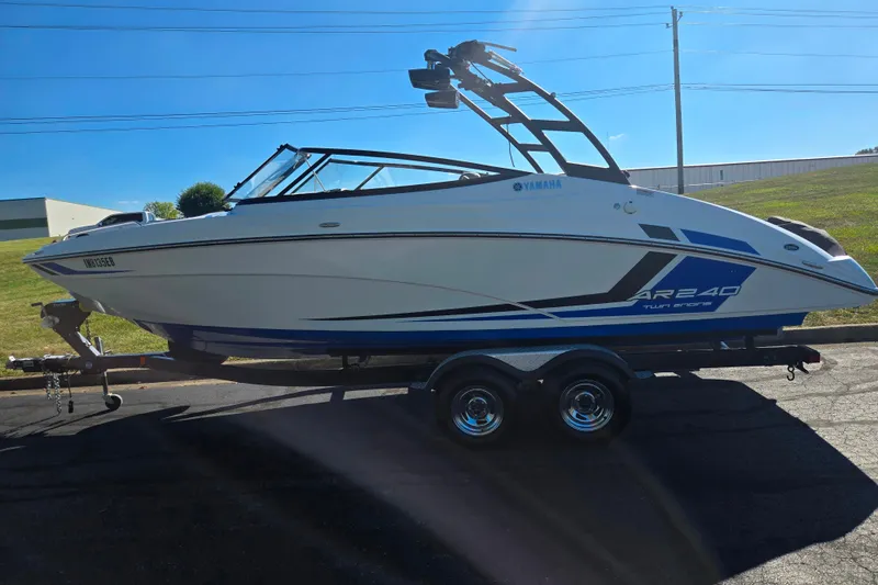 Slide: The Image of 2018 Yamaha Boats AR240 on trailer, sleek design, blue accents, sunny day. - 4