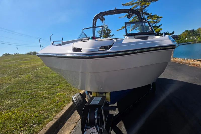 Slide: The Image of 2018 Yamaha Boats AR240 on trailer, parked near a lake under clear blue sky. - 6