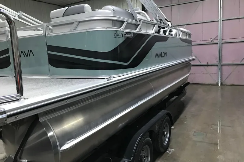 Slide: The Image of 2026 Avalon Venture Quad Lounger 19' pontoon boat in a garage setting. - 10