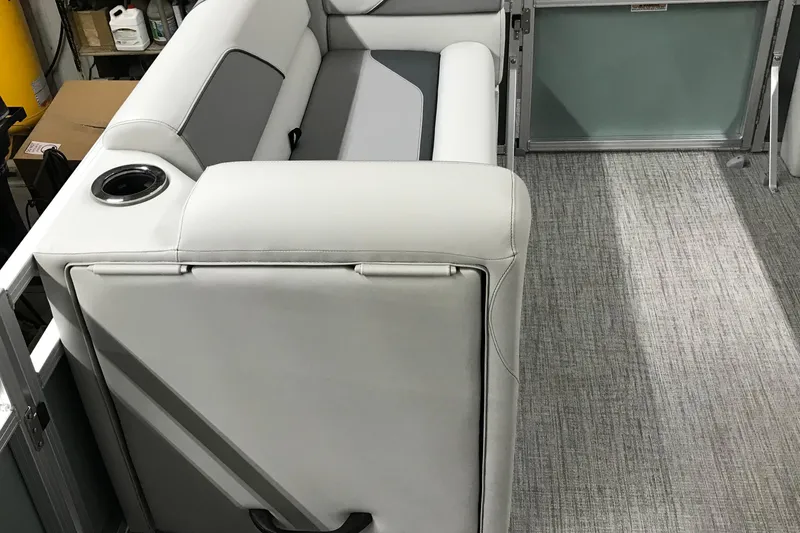 Slide: The Image of 2026 Avalon Venture Quad Lounger 19' interior with gray seating and cup holder. - 20
