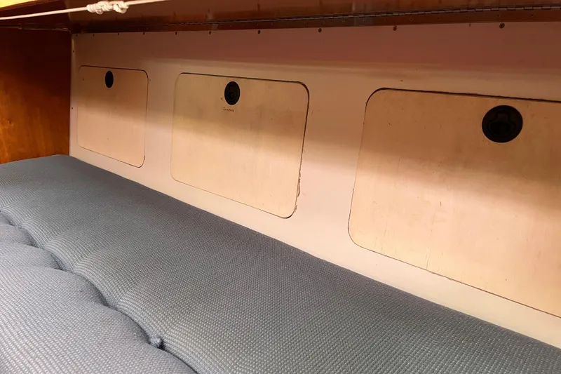 Slide: The Image of Interior of 1995 Able Apogee 50 with blue cushioned seating and storage compartments. - 29