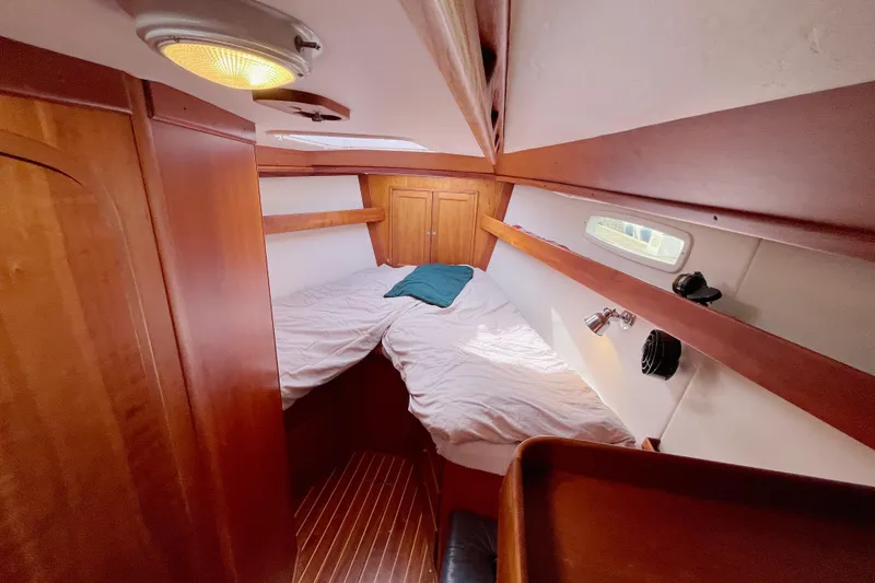 Slide: The Image of Cozy cabin interior of 1995 Able Apogee 50 sailboat with wooden finishes and bedding. - 2