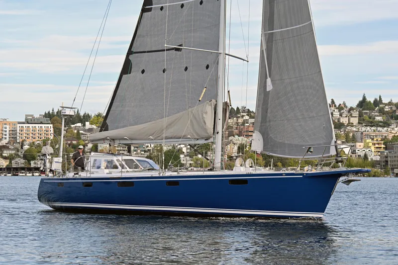 Slide: The Image of Sailing yacht Able Apogee 50, 1995 model, cruising on a calm lake with cityscape backdrop. - 78