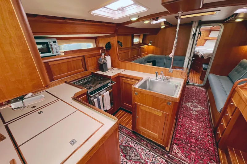 Slide: The Image of Luxurious 1995 Able Apogee 50 yacht interior with wood finish, kitchen, and seating area. - 13