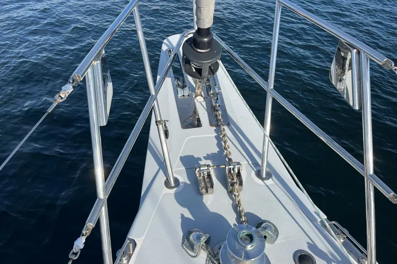 Slide: The Image of Bow of 1995 Able Apogee 50 sailboat with anchor chain over calm water. - 43