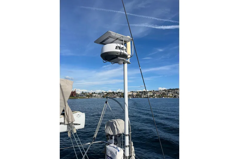 Slide: The Image of Sailboat mast with radar and solar panel, Able Apogee 50, 1995, on calm water. - 64