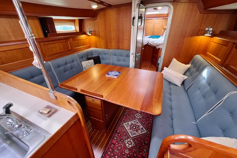 Slide: The Image of Luxurious 1995 Able Apogee 50 yacht interior with wooden dining area and blue seating. - 7