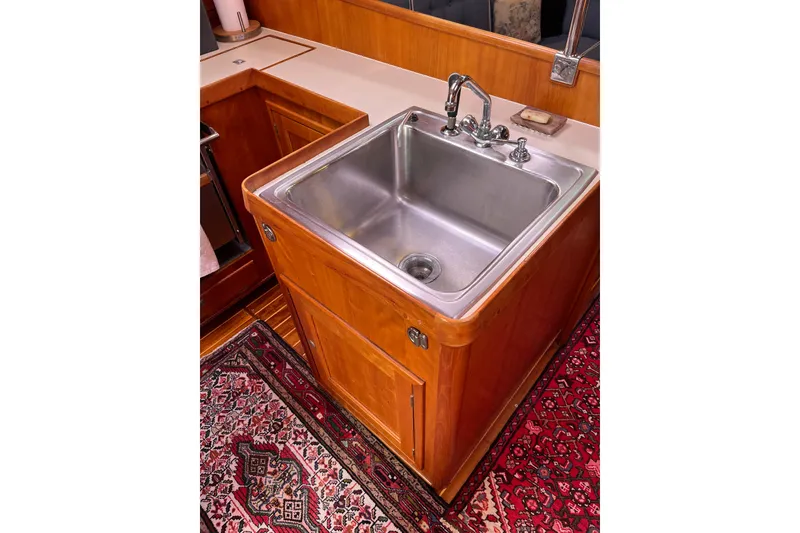 Slide: The Image of Stainless steel sink in wooden cabinet, Able Apogee 50 yacht, 1995, with decorative rug. - 24
