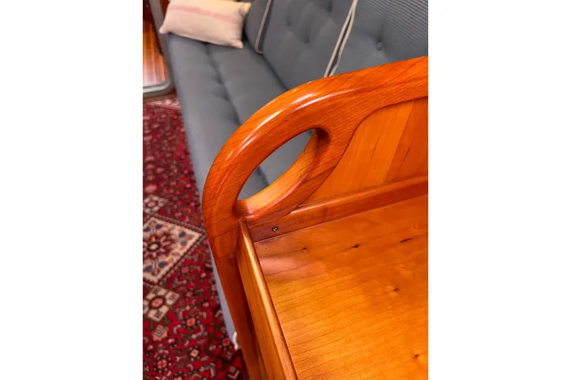 Slide: The Image of Polished wooden furniture detail with blue sofa and patterned red rug, Able Apogee 50, 1995. - 27