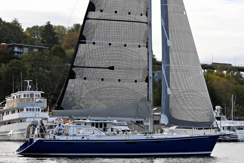 Slide: The Image of Sailing yacht Able Apogee 50, 1995 model, cruising near a scenic waterfront. - 79