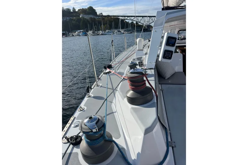 Slide: The Image of Sailboat deck view of 1995 Able Apogee 50, featuring winches and marina background. - 69