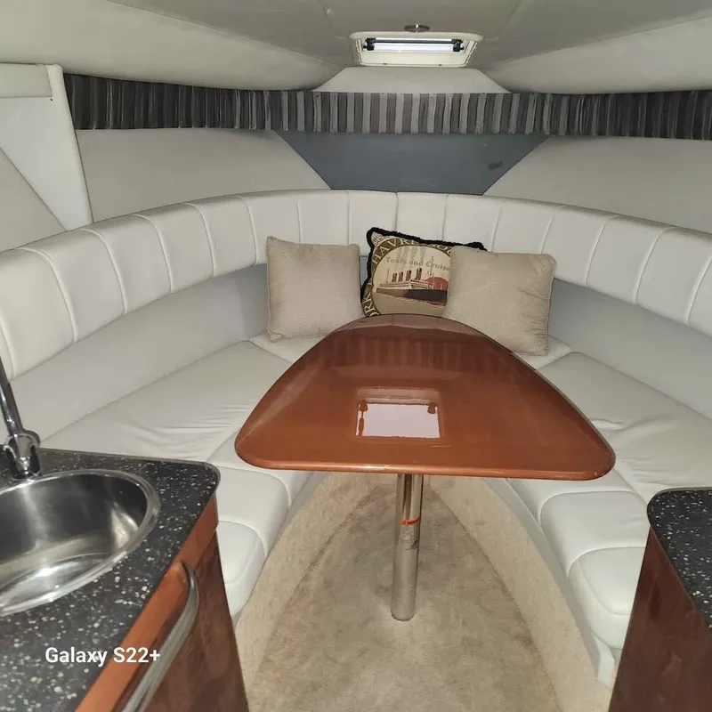 Slide: The Image of Interior of a 2006 Formula 27 PC boat with white seating and wooden table. - 4