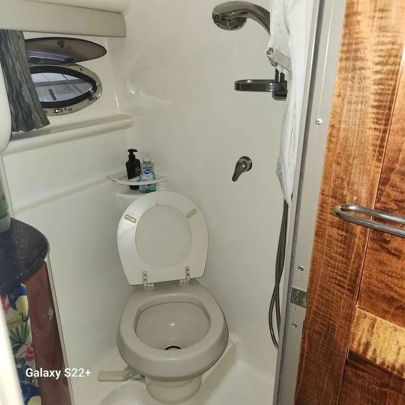 Slide: The Image of Compact bathroom in a 2006 Formula 27 PC boat, featuring a toilet and shower. - 5
