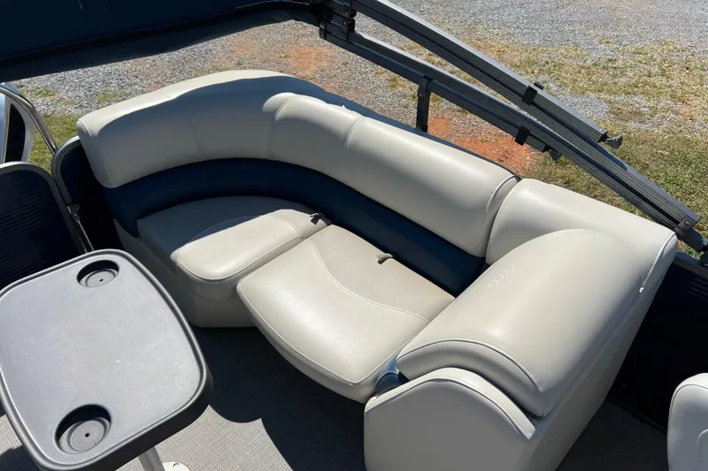 Slide: The Image of 2020 Manitou 23 Aurora LE Standard boat interior with plush seating and table. - 10