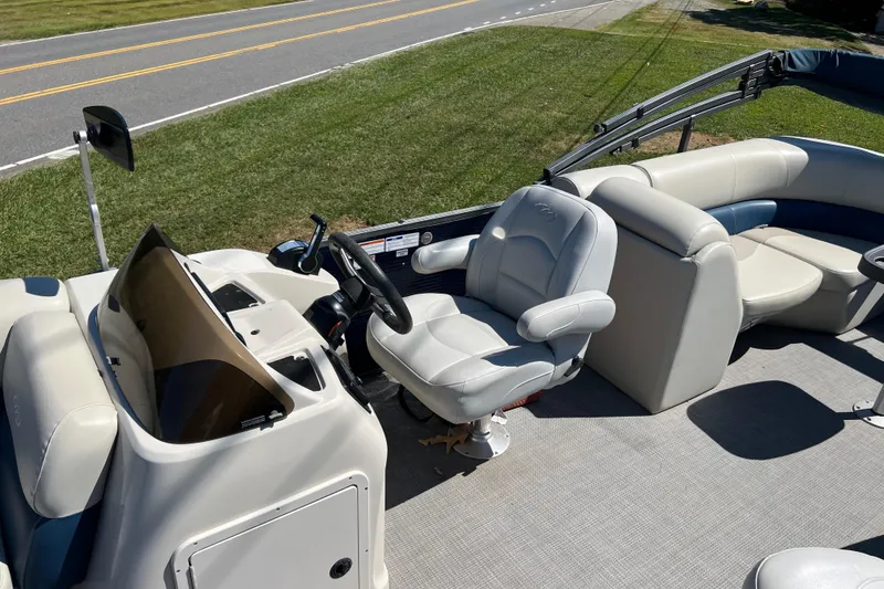 Slide: The Image of 2020 Manitou 23 Aurora LE Standard pontoon boat interior with captain's chair and console. - 7