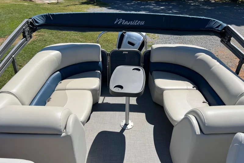 Slide: The Image of 2020 Manitou 23 Aurora LE Standard pontoon boat interior with seating and table. - 9