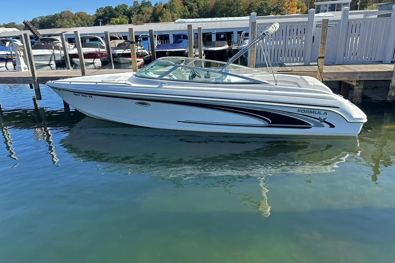 Slide: The Image of 2005 Formula 260 Sun Sport boat docked at marina, reflecting on calm water. - 1