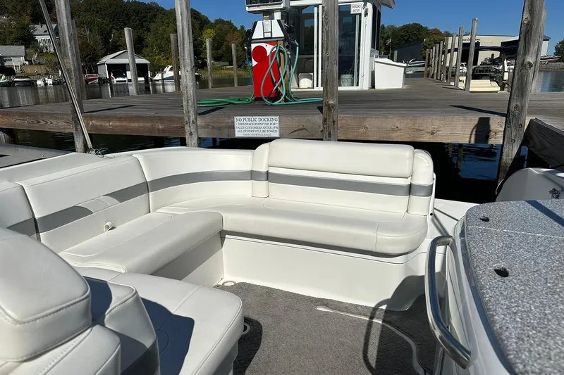 Slide: The Image of 2005 Formula 260 Sun Sport boat interior with white seating at a dock. - 16