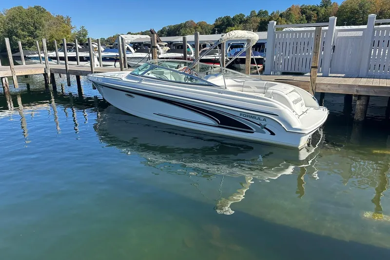 Slide: The Image of 2005 Formula 260 Sun Sport boat docked on calm water, clear sky background. - 4