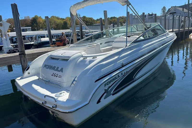 Slide: The Image of 2005 Formula 260 Sun Sport boat docked at marina, sleek white design. - 5