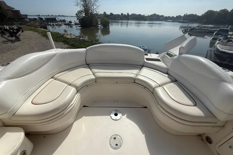 Slide: The Image of 2001 Sea Ray 280 Bow Rider with spacious white seating, docked by a serene lake. - 10