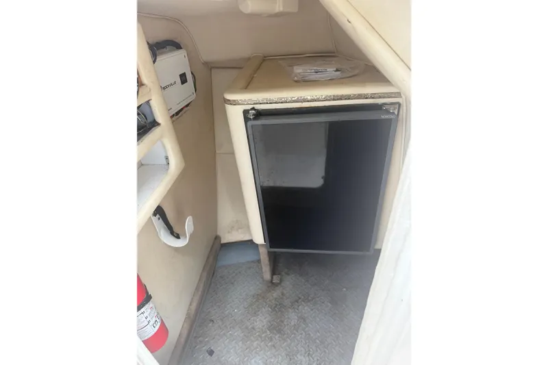 Slide: The Image of 2001 Sea Ray 280 Bow Rider interior with mini fridge and fire extinguisher. - 13