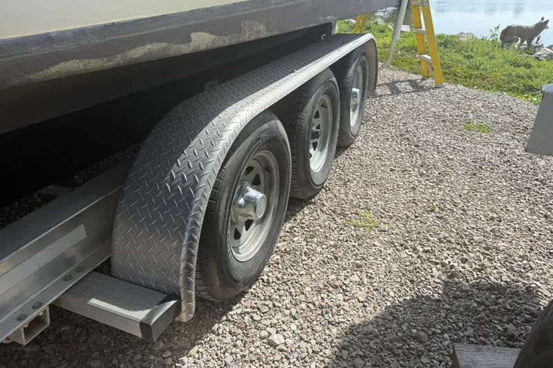 Slide: The Image of Triple-axle trailer for 2001 Sea Ray 280 Bow Rider on gravel surface. - 3