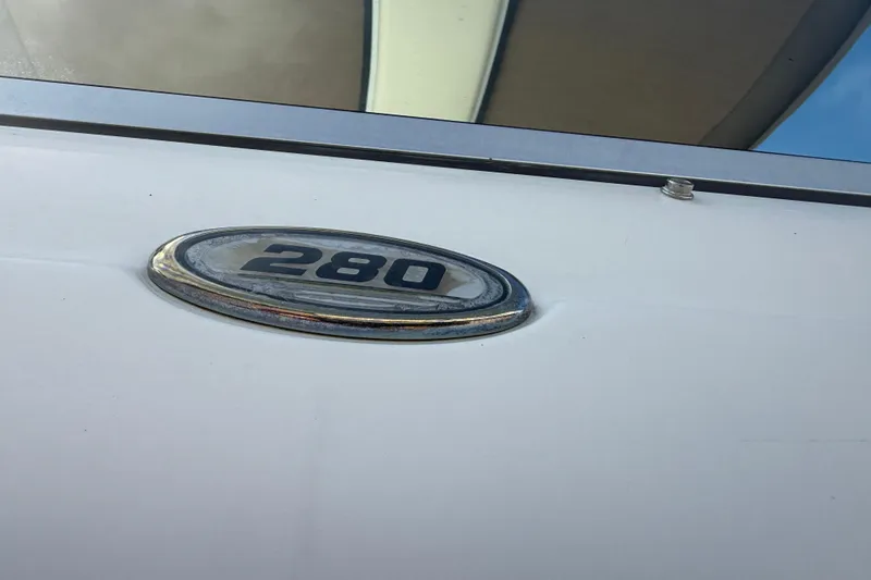 Slide: The Image of 2001 Sea Ray 280 Bow Rider emblem on white boat exterior. - 4
