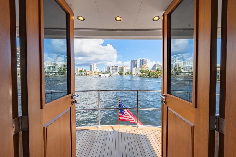 Slide: The Image of View from 1984 Feadship Yacht Fish, open doors, city skyline, and American flag. - 37