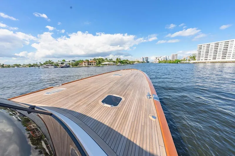 Slide: The Image of Luxurious 1984 Feadship Yacht Fish on calm waters, clear sky, and scenic waterfront view. - 42