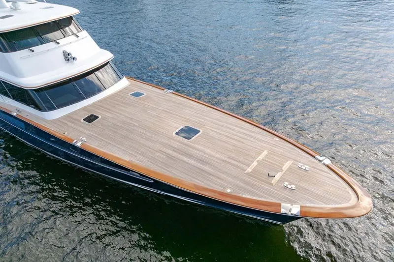 Slide: The Image of 1984 Feadship Yacht Fish with sleek wooden deck on calm water. - 45