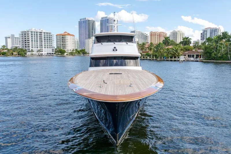 Slide: The Image of Front view of 1984 Feadship Yacht Fish on water, with city skyline background. - 46