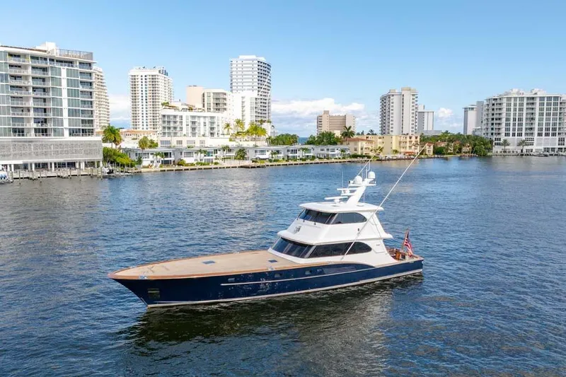 Slide: The Image of 1984 Feadship Yacht Fish cruising near modern waterfront buildings. - 48
