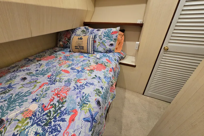 Slide: The Image of Cozy cabin bedroom in 1982 Ocean Yachts 55 Super Sport, featuring nautical-themed bedding. - 19