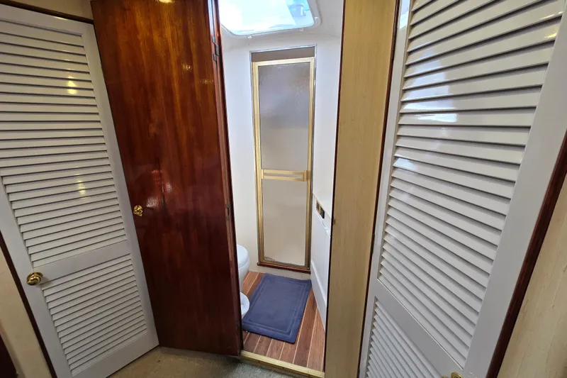 Slide: The Image of Interior of 1982 Ocean Yachts 55 Super Sport, featuring wooden doors and a compact bathroom. - 22