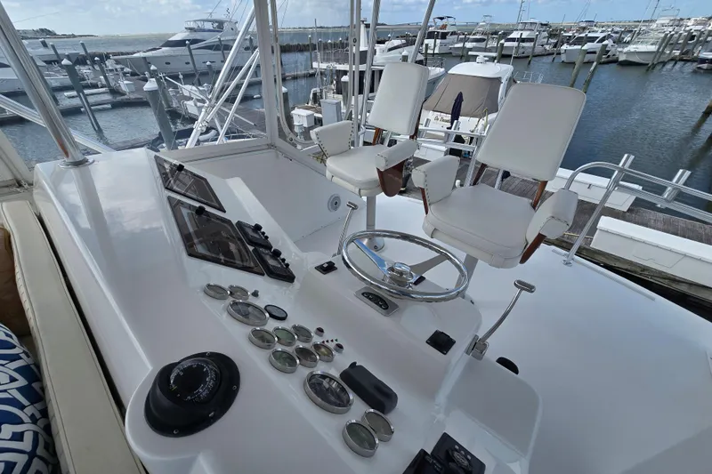 Slide: The Image of Cockpit of Ocean Yachts 55 Super Sport 1982, featuring helm and gauges at marina. - 31