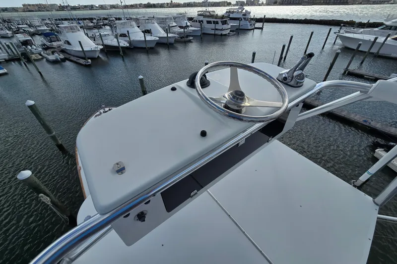 Slide: The Image of Helm of Ocean Yachts 55 Super Sport 1982, overlooking marina with docked boats. - 36