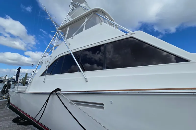 Slide: The Image of Ocean Yachts 55 Super Sport 1982 model, docked under a blue sky with clouds. - 6